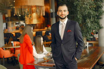 Man and two beautiful women working. People in a cafe. Women in a elegant suit cases