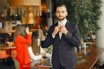 Man and two beautiful women working. People in a cafe. Women in a elegant suit cases
