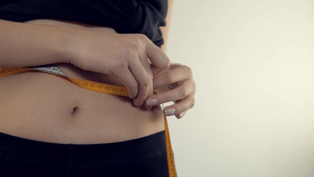 Woman Looking Down Measuring Waist With Measuring Tape Closeup High-Res  Stock Photo - Getty Images
