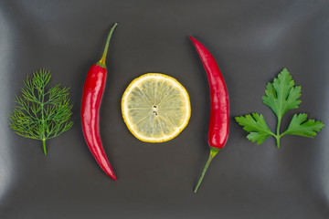 Fresh red hot peppers and lemon on a plate. Vitamin wholesome food.