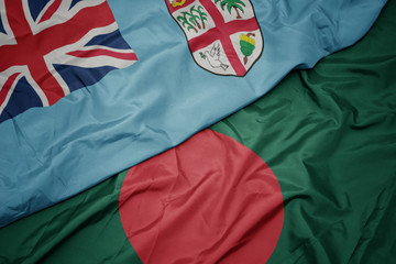 waving colorful flag of bangladesh and national flag of Fiji .