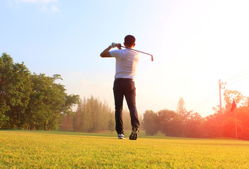 The male golf player on the competition field Start playing golf ball On the green lawn background