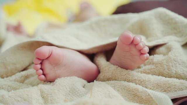 Newborn feet in bed, close-up