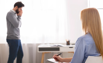 Stressed man emotionally speaking at psychotherapist session