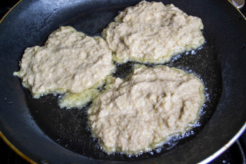 Fried potato pancakes, boiling oil, top view, selective focus, blur background