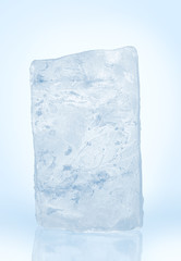 Chrystal frosted clear natural ice block in cold light blue tones on reflective surface. Clipping path included.