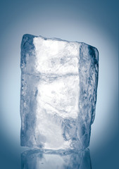 Chrystal clear natural ice block in cold blue tones on reflective surface. Clipping path included.