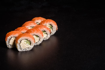 Various kinds of sushi served on a dark background
