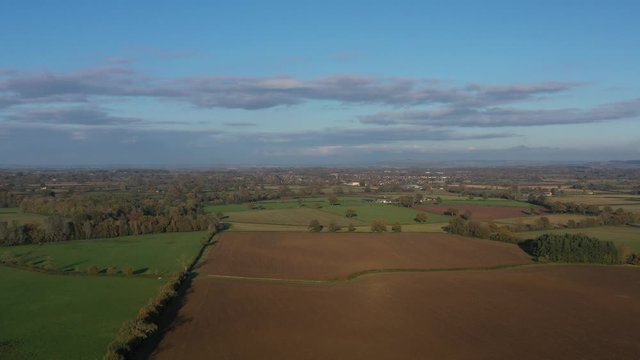 Wide aerial orbit view of Moreton-In-Marsh, autumnal landscape of the Cotswolds.