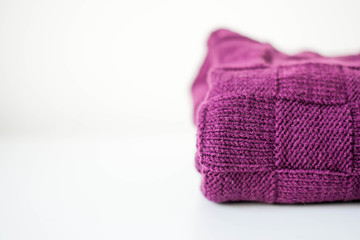 Knitted knitted fabric, plaid purple on white background. Copy space.
