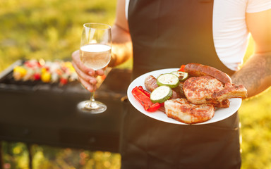Faceless male with grilled food and wine