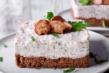 Salty mini cheesecake with roasted mushrooms and parsley on a ceramic plate