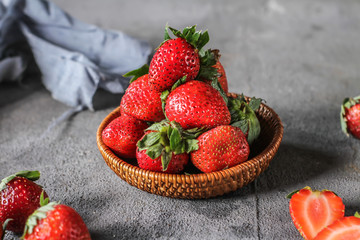 Photo of heap of fresh strawberries in the bowl on rustic grey background..A bunch of ripe strawberries in a wooden bowl on the table. Copy space. Healthy fresh fruit. Organic food. Wooden basket
