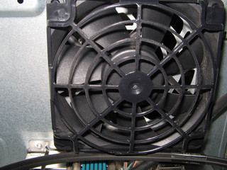 Cooling fan system of computer. Big black plastic cooler set on heat exchanger inside industrial system electronics.