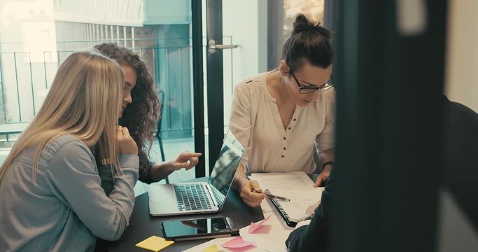4K slow motion. Discussing of young business people. Mixed race creative team meeting in modern work space. We are stronger together.