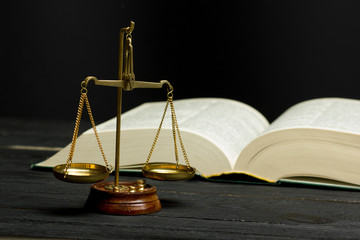 Law concept - Open law book with a wooden judges gavel on table in a courtroom or law enforcement office isolated on white background. Copy space for text.