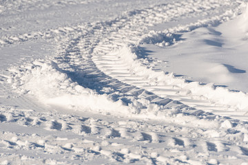 Tire tracks on winter road. Frozen road, transportation in snow.