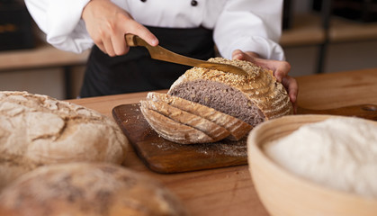Crop baker cutting bread