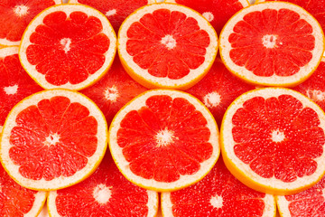 Grapefruit red juicy slices background. top view