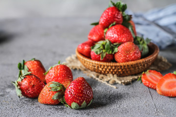 Photo of heap of fresh strawberries in the bowl on rustic grey background..A bunch of ripe strawberries in a wooden bowl on the table. Copy space. Healthy fresh fruit. Organic food. Wooden basket