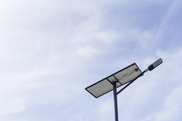 The lamp post and photovoltaic panel with blue sky background