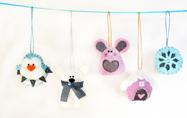 Various Christmas decorations hanging on ribbon