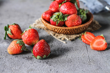 Photo of heap of fresh strawberries in the bowl on rustic grey background..A bunch of ripe strawberries in a wooden bowl on the table. Copy space. Healthy fresh fruit. Organic food. Wooden basket