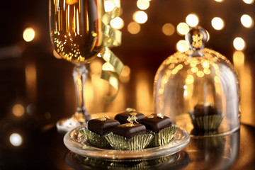  Christmas or New Year's composition with glass of champagne and mini cakes, selective focus