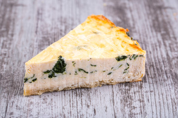 Piece of pie with parmesan cheese and spinach