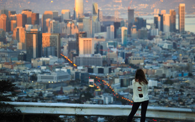 alone girl looks at the town from above and thinks about the future
