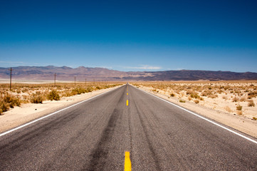 Fototapeta na wymiar Long straight road in the desert, USA