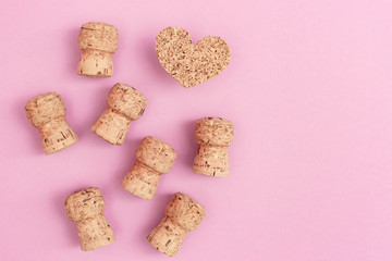 Many corks from champagne and heart on pink paper background with copy space. Flat lay for Birthday, party, wedding. Hen party invitation.