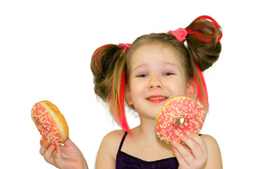 A little girl holds two donuts like glasses near her eyes