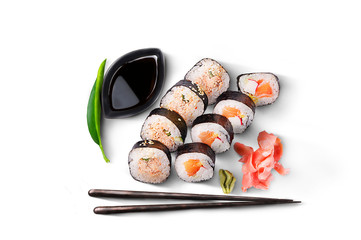 A maki sushi set. 8 pieces with salmon, wasabi, ginger, soy sauce and chopsticks. A packshot photo,...
