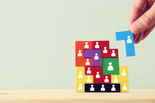 Business concept image of tangram puzzle blocks with people icons over wooden table, human resources and management concept