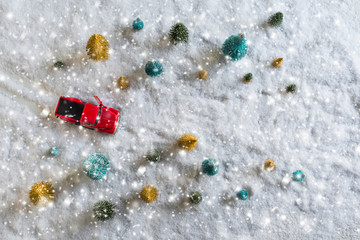 Creative Christmas decoration with red truck and colorful snowy spruces in the snow. Winter forest. Aerial, top view. Flat lay