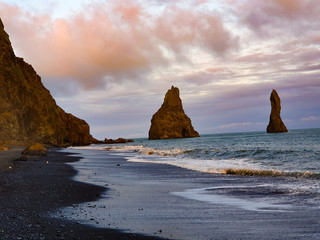 Rocks in the sea on  black beach in Iceland 