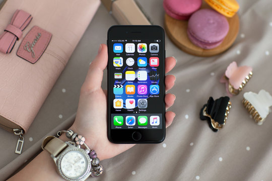 Woman hand with Watch holding iPhone 7 Jet Black Onyx