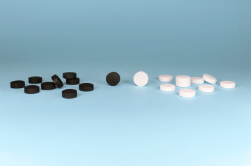 Assorted pharmaceutical medicine pills, tablets and capsules on a blue background