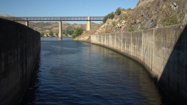 Cruise river boat starts to leave the lock of Barragem do Pocinho dam on the Douro ready for the cruising down the next section of the river