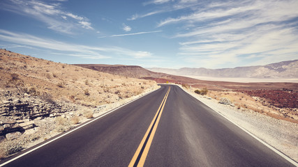 Desert road in Death Valley, color toning applied, USA.