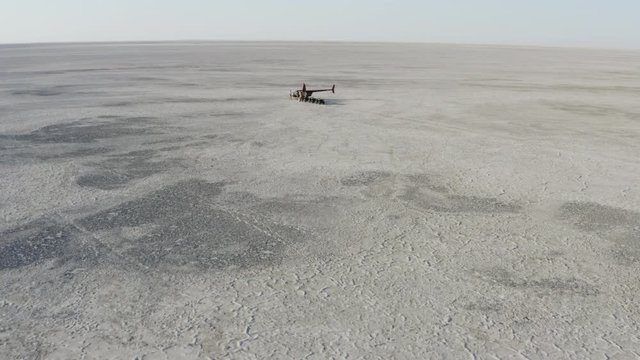 Aerial fly over view of a helicopter with tourists and quad bikes the Makgadikgadi Pans,Botswana