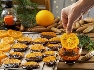 Christmas sweets, candied fruits in chocolate. Caramelized orange slices on a light paper background. Homemade dessert. Cooking sweets.