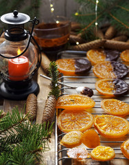Christmas sweets, candied fruits in chocolate. Caramelized orange slices on a light paper background. Homemade dessert. Cooking sweets. close-up