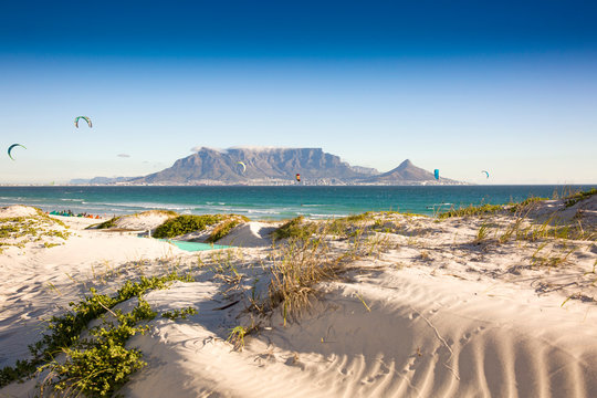 Beach dunes and kite surfers at Blouberg beach with in the background Cape Town and Table Mountain