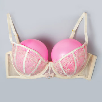 Bra with pink balloons on a gray background. Fun, conceptual photo, great big breasts.
