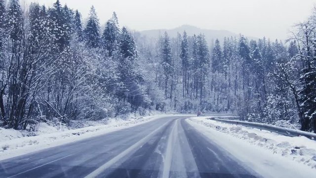 driving on the winter forest road in heavy snowfall, beautiful landscape