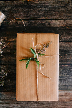 Present wrapped in brown paper with string and flowers