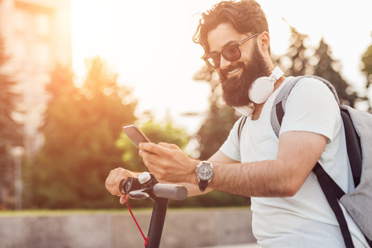Cheerful hipster using smartphone during ride