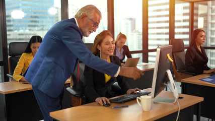 Senior employee discussing with business woman at workplace